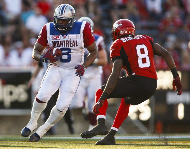 Montreal Alouettes' Nik Lewis, left, tries to get past Calgary Stampeders' Fred Bennett during second half CFL football action in Calgary on Saturday, August 1, 2015. 