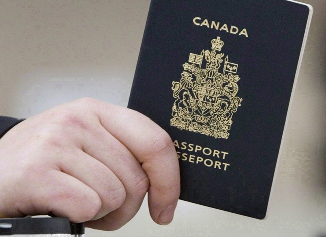 A passenger holds a Canadian passport before boarding a flight in Ottawa on Jan 23, 2007.