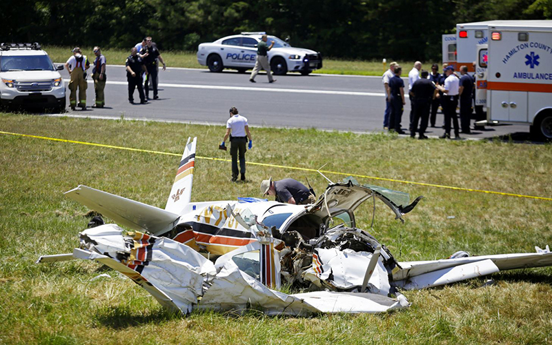 Investigators work the scene of a plane crash next to the runway of the Collegedale Municipal Airport on Saturday, June 11, 2016, in Collegedale, Tenn. 