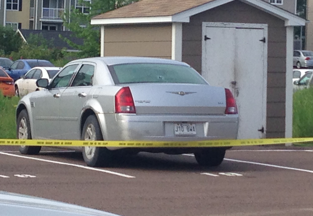 A car is seen with a bullet hole in the back windshield in the parking lot of an apartment building in Dieppe. 