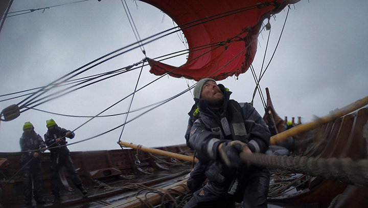 Draken crew member pulls in the sail as the ship nears Shetland Islands.