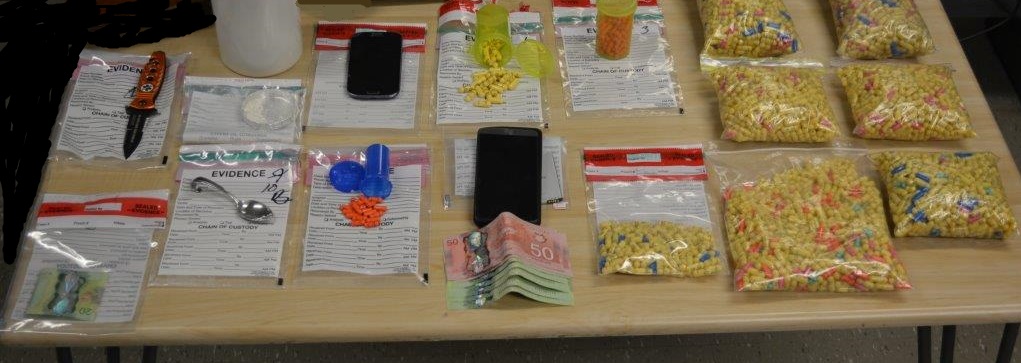 A quantity of prescription pills, cash and marihuana seized.