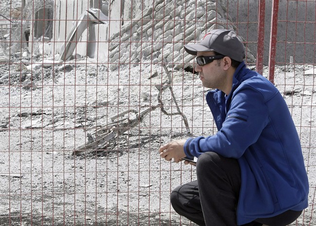 Farid El-Hayouni looks at the charred remains of his son's bike in Fort McMurray, Alta. on Friday, June 3, 2016.