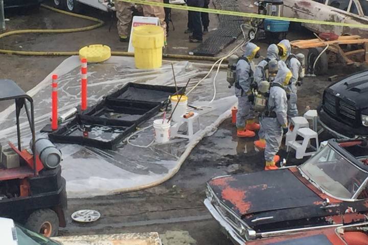 Police in haz-mat suits search business premises.