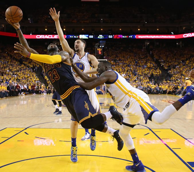 Cleveland Cavaliers forward LeBron James (L) goes to the basket against Golden State Warriors players Klay Thompson (C) and Draymond Green (R) during the second half of the NBA Finals basketball game two between the Cleveland Cavaliers and the Golden State Warriors at the Oracle Arena in Oakland, California, 05 June 2016.