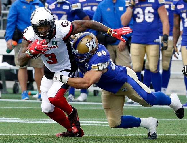 Ottawa Redblacks' Travon Van is tackled by Winnipeg Blue Bombers' Ian Wild during a pre-season game in Ottawa on June 13, 2016.