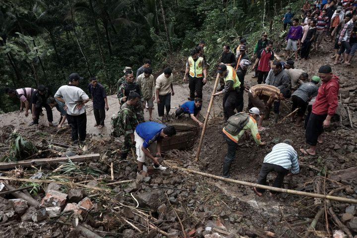 Indonesian villagers and search and rescue team members clear debris after a landslide hit Gumelem Kulon village in Banjarnegara on June 19, 2016.  


Flash flooding and landslides in Indonesia have killed 24 and left more than two dozen missing, an official said on June 19, with mud avalanches burying people inside their homes. 