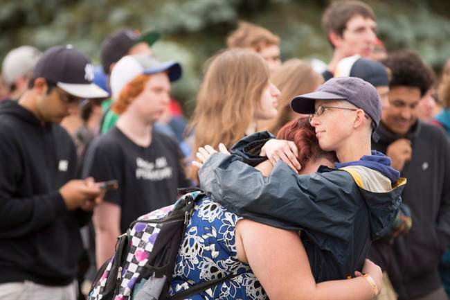 A woman is comforted during a rally in Woodstock, Ont. after hundreds of high school students in the town walked out of classes, Tuesday, June 7, 2016.