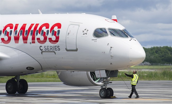 A ground crew operator detaches a cable from a Bombardier C Series 100 aircraft prior to a demonstration flight in Mirabel, Que., Wednesday, June 29, 2016.