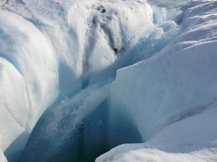 Melt water pours through a channel in Greenland’s ice.