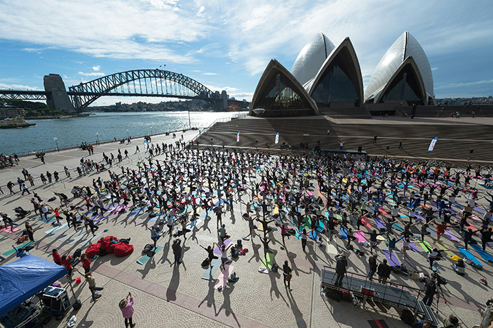 People attend a yoga event in front of the Australia’s iconic landmark Opera House in Sydney on June 21, 2016.