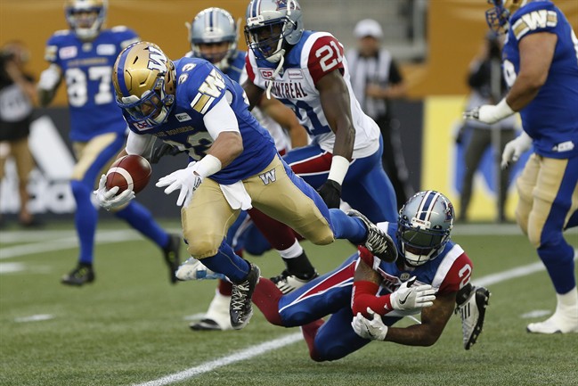 Despite Montreal Alouettes' Jovon Johnson (2) getting a hand on Winnipeg Blue Bombers' Andrew Harris (33) he can't stop the running back during the first half of pre-season CFL action in Winnipeg Wednesday, June 8, 2016. THE CANADIAN PRESS/John Woods.