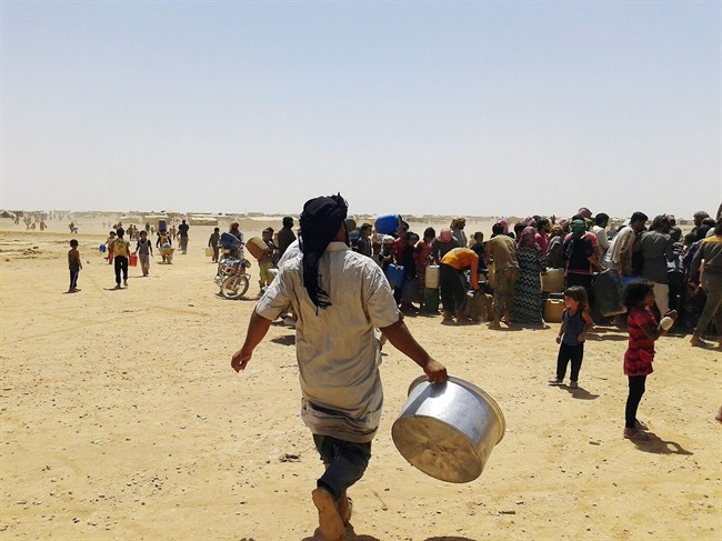 In this Tuesday, June 28, 2016 photo, Syrian refugees gather for water at Ruqban border camp in northeast Jordan. (AP Photo).