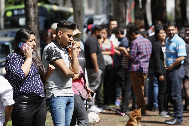 People stand in the streets after a 5.7-magnitude earthquake, 22km north from Pinotepa de Don Luis, Mexico, triggered alarms, in Mexico City, Mexico, 27 June 2016.