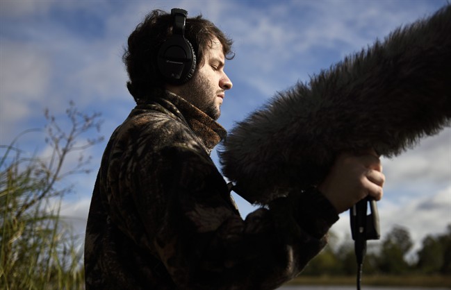 In this June 1, 2016 photo, Juan Pablo Culasso holds a microphone in a natural reserve on the outskirts of Montevideo, Uruguay. Although Culasso can distinguish light, allowing him to differentiate night from day, he cannot register shapes, forms, and even less so the colors of birds. His ears have always been his way to connect more profoundly with the world. His ability to recognize and record nature's sounds has landed him jobs working for documentary soundtracks. (AP Photo/Matilde Campodonico).