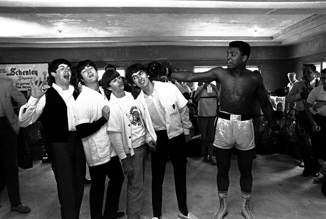 In this Feb. 18, 1964, file photo, the Beatles, from left, Paul McCartney, John Lennon, Ringo Starr, and George Harrison, take a fake blow from Cassius Clay (Muhammad Ali) while visiting the heavyweight contender at his training camp in Miami Beach, Fla.