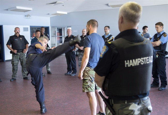 Security officer Michael Huculak, left, watches a demonstration during a training course Wednesday, June 1, 2016 in Montreal. Every year, Huculak and his fellow Hampstead officers take part in a one-day training course on how to use the 55-centimetre, steel baton as well as learning about hand-to-hand combat techniques and the use of handcuffs. THE CANADIAN PRESS/Paul Chiasson.