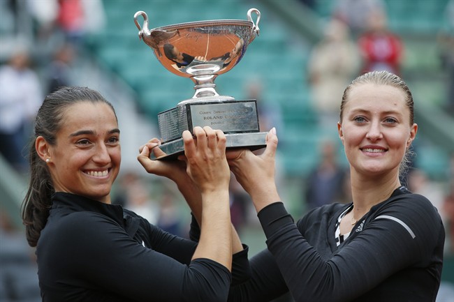 Caroline Garcia, left, and Kristina Mladenovic of France celebrate with the trophy after winning the women's doubles final of the French Open tennis tournament.