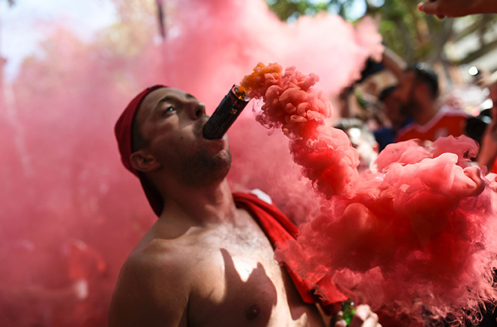 A Wales’ supporter cheers with a flare in his mouth downtown Toulouse, southern France, on June 20, 2016 before the Euro 2016 football match of Russia vs Wales.