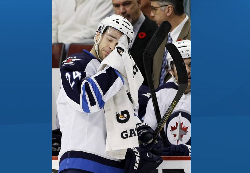 Winnipeg Jets' Grant Clitsome wipes his face during the first period of an NHL hockey game against the Chicago Blackhawks on November 6, 2013.