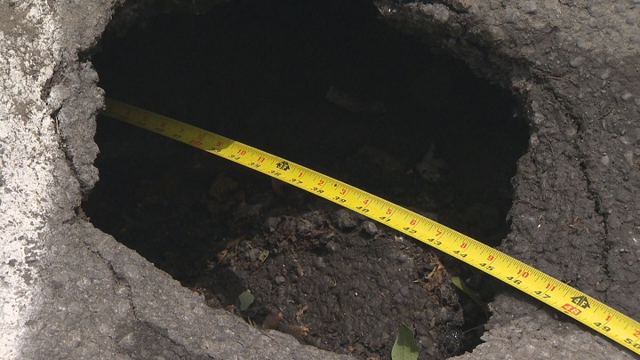 The pothole is deep and has residents and nearby workers it could soon collapse and turn into a massive sinkhole. Tuesday, June 7, 2016.