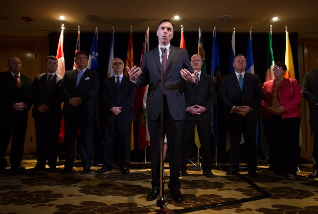 Federal Finance Minister Bill Morneau, centre, is flanked by his provincial and territorial counterparts as he speaks during a news conference after reaching a deal to expand the Canada Pension Plan, in Vancouver, B.C., on Monday June 20, 2016. THE CANADIAN PRESS/Darryl Dyck.