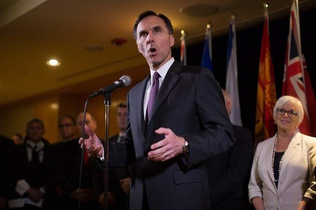 Federal Finance Minister Bill Morneau is flanked by his provincial and territorial counterparts as he speaks during a news conference after reaching a deal to expand the Canada Pension Plan, in Vancouver, B.C., on Monday June 20, 2016. 