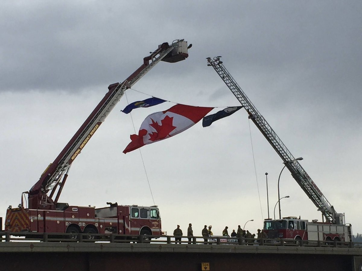 Firefighters set up on an overpass to welcome home Fort McMurray residents Wednesday, June 1, 2016.