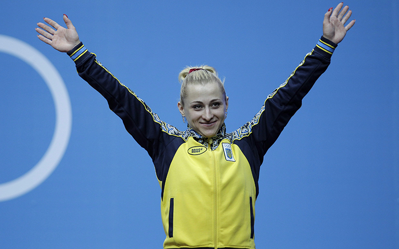 Ukraine's Yuliya Kalina waves before receiving her bronze medal during a ceremony after the women's 58-kg weightlifting competition at the 2012 Summer Olympics, Monday, July 30, 2012, in London. 