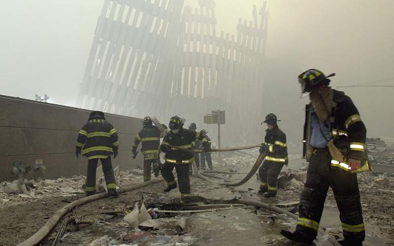 Firefighters work beneath the destroyed mullions, the vertical struts which once faced the soaring outer walls of the World Trade Center towers. 