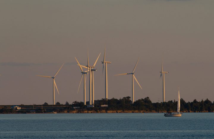 A sailboat makes its way past Wolfe Island's wind turbines on Lake Ontario near Kingston, Ont.