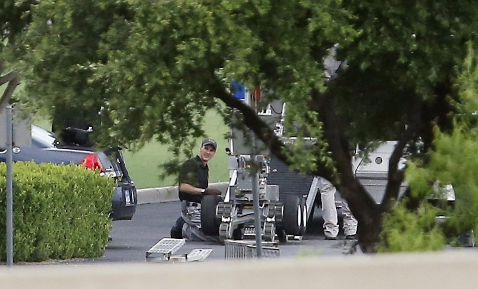 Police appear to setup a remotely operated robot during a stand off with a gunman barricaded inside a van at a Jack in the Box restaurant at Interstate 45 and Dowdy Ferry Road, Saturday, June 13, 2015, in Hutchins, Texas. The gunman allegedly attacked Dallas Police Headquarters.