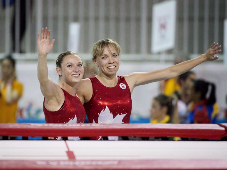 Rosie MacLennan, left, and Karen Cockburn celebrate their gold and bronze medals respectively during trampoline finals at the Pan Am Games in Toronto on July 19, 2015.