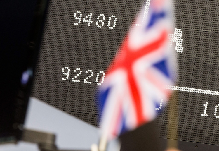 A British flag is seen in front of the DAX index display board at the stock exchange in Frankfurt, 24 June 2016, after the result of the British EU referendum. 