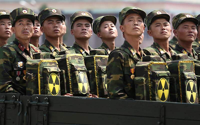 North Korean soldiers turn and look towards leader Kim Jong Un as they carry packs marked with the nuclear symbol as they parade during a ceremony marking the 60th anniversary of the Korean War armistice in Pyongyang, North Korea On July 27, 2016.