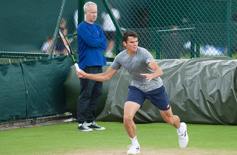 Milos Raonic in action during Sunday's practice with his coach John McEnroe looking on, 2016 Wimbledon Tennis Championships, Sunday Practice Day,  AELTC, London, Britain.
