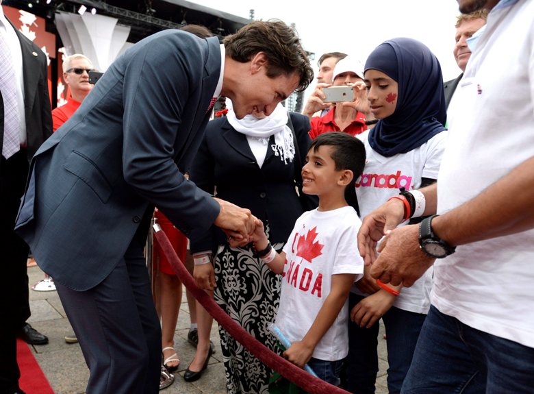 Prime Minister Justin Trudeau greets members of a Syrian refugee family during Canada Day celebrations on Parliament Hill, in Ottawa on Friday, July 1, 2016.