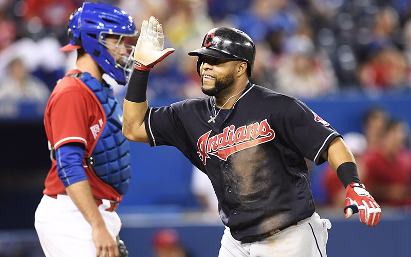 Cleveland Indians' Carlos Santana celebrates his home run in front of Toronto Blue Jays catcher Josh Thole during nineteenth inning MLB baseball action, in Toronto on Friday, July 1, 2016. 