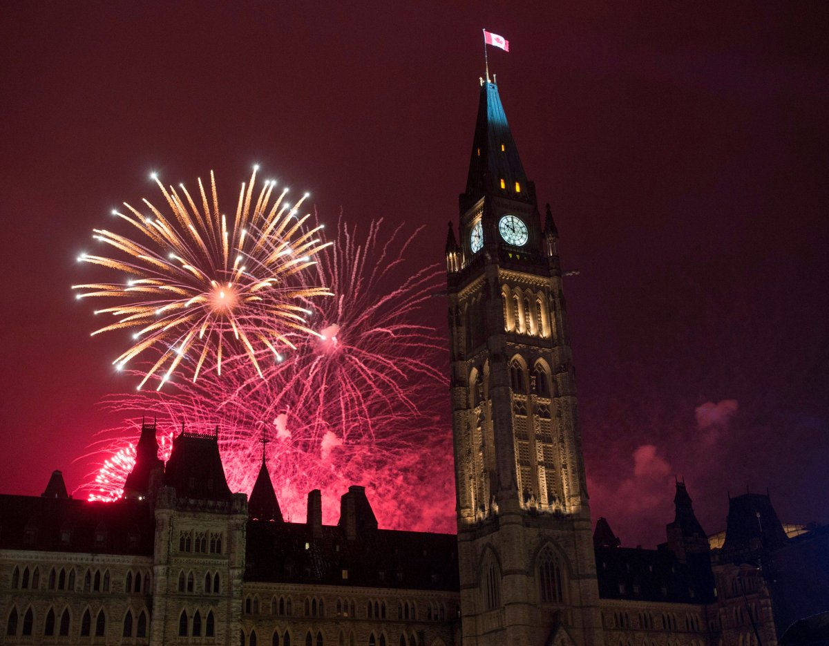 Fireworks light up the sky red behind the Peace Tower during Canada Day celebrations on Parliament Hill on Friday, July 1, 2016 in Ottawa. 