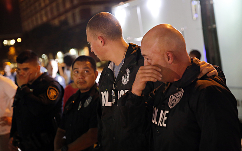 Dallas Police Department officers visit a memorial in front of police headquarters, in Dallas. Five police officers were killed the previous evening when a sniper opened fire on a Black Lives Matter rally downtown. 