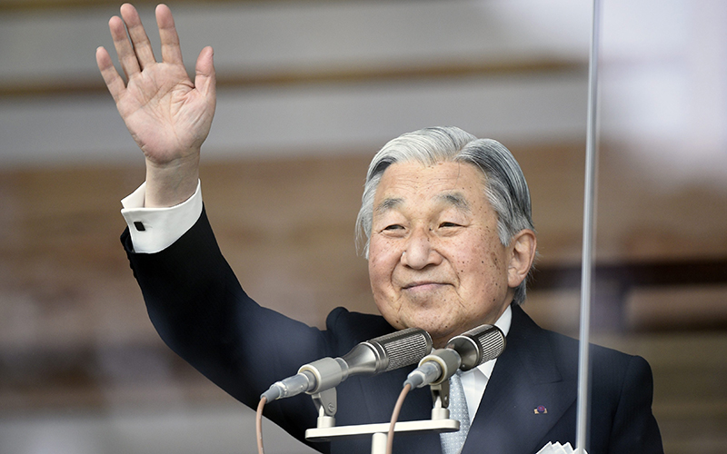 Japan's Emperor Akihito waving to well-wishers through a bullet-proof glass from a balcony during the New Year's public appearance at the Imperial Palace in central Tokyo, Japan.   