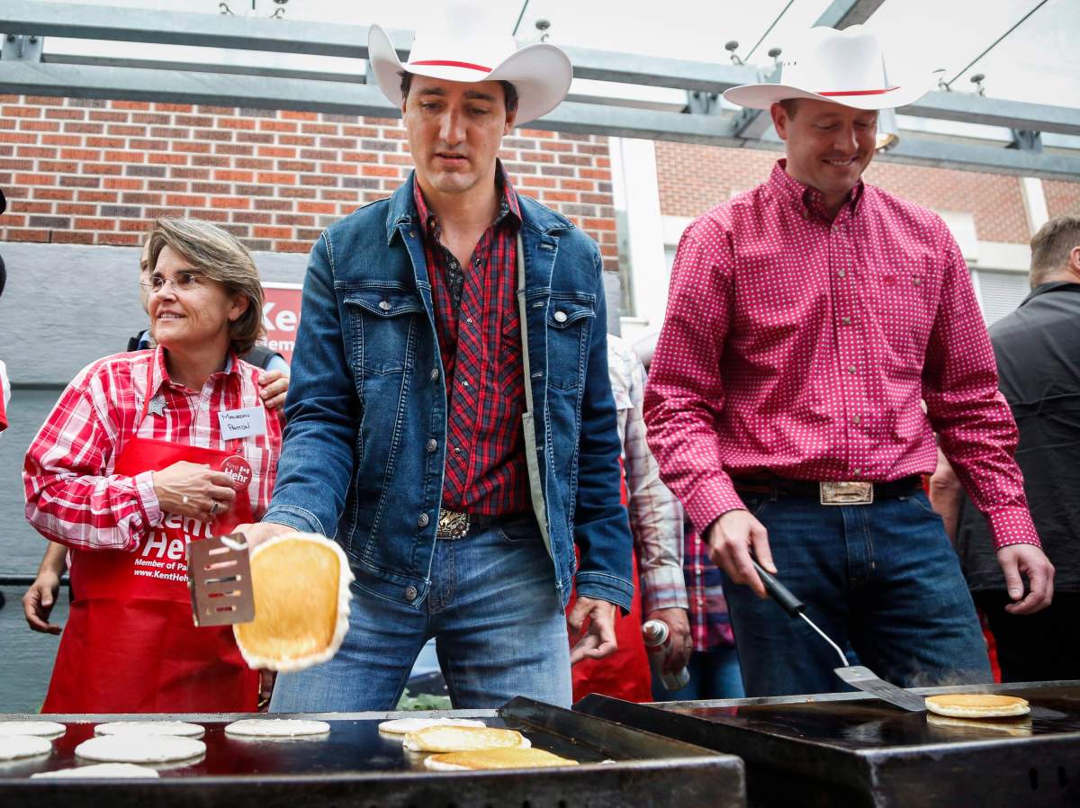 Prime Minister Justin Trudeau, centre, flips flapjacks at a Stampede breakfast in Calgary, Alta., Saturday, July 16, 2016.