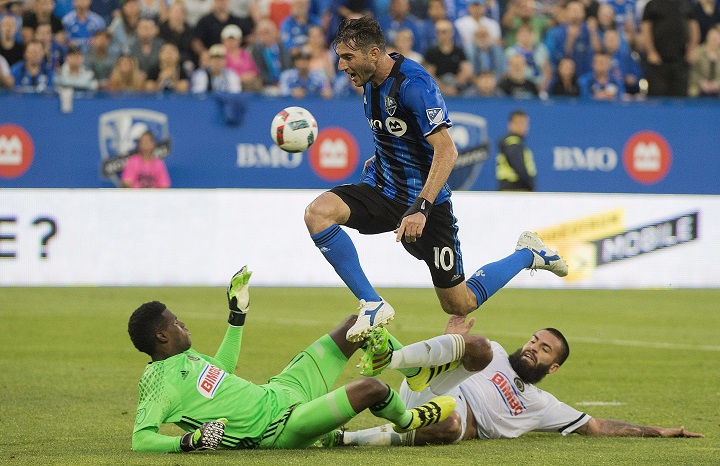 Montreal Impact's Ignacio Piatti, centre, leaps over Philadelphia Union's goalkeeper Andre Blake and defender Richard Marquez, right, during first half MLS soccer action in Montreal, Saturday, July 23, 2016.