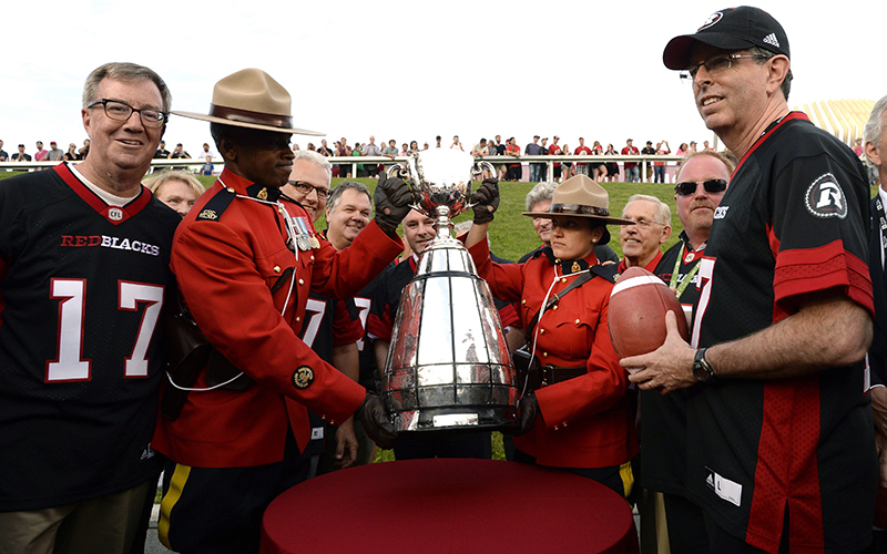 Mayor Jim Watson, left, and Roger Greenberg, right, look on as Ottawa is announced as the host of the 2017 Grey Cup championship, before CFL action between the Ottawa Redblacks and the Toronto Argonauts, in Ottawa on Sunday, July 31, 2016.