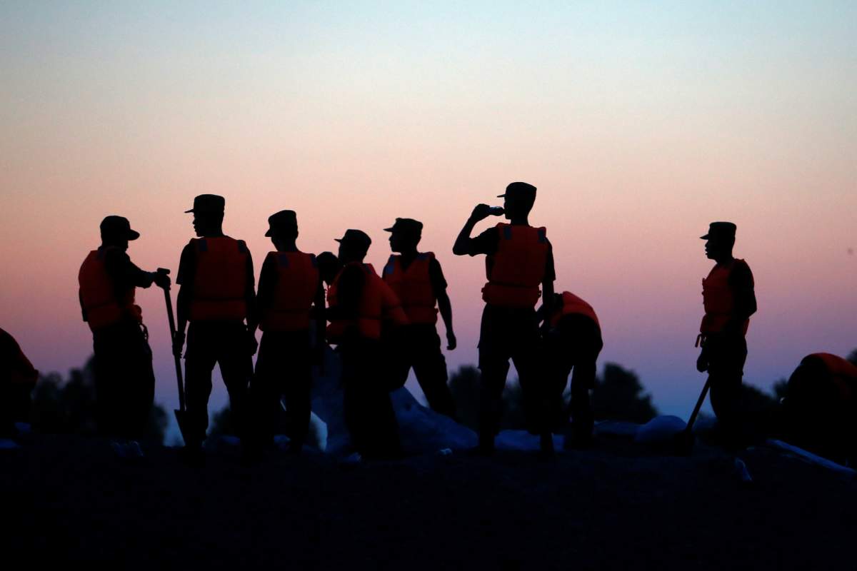 Rescue workers are seen as they fill sand bags near a flooded area in Xiaogan, Hubei Province, China, July 22, 2016. Picture taken July 22, 2016.