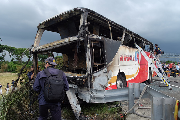 Investigators inspect a bus carrying tourists from mainland China that crashed and caught fire along an expressway on its way to the airport in Taiwan's city of Taoyuan on July 19, 2016.
The Taiwan tour bus carrying visitors from mainland China crashed and caught fire on July 19 near the capital Taipei, killing 26 on board.