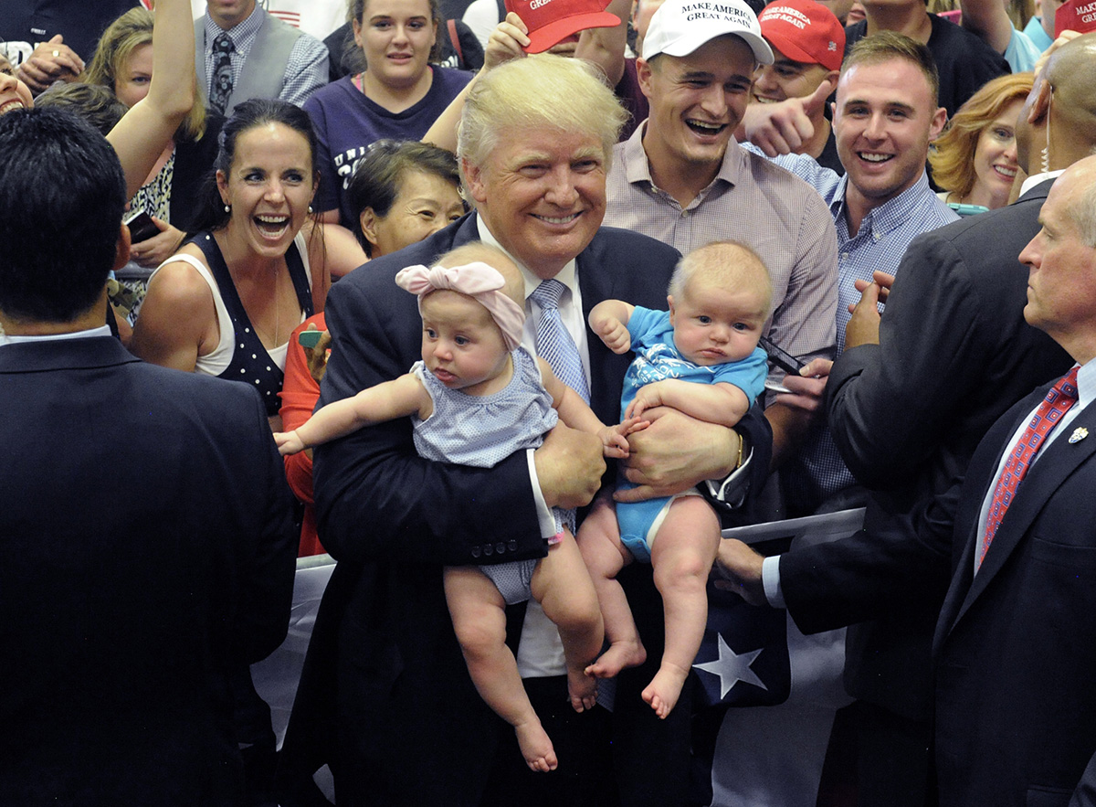 US Republican Presidential Candidate Donald Trump holds two babies after his Town Hall address at the Gallogly Events Center in Colorado Springs, Colorado, on July 29, 2016.  