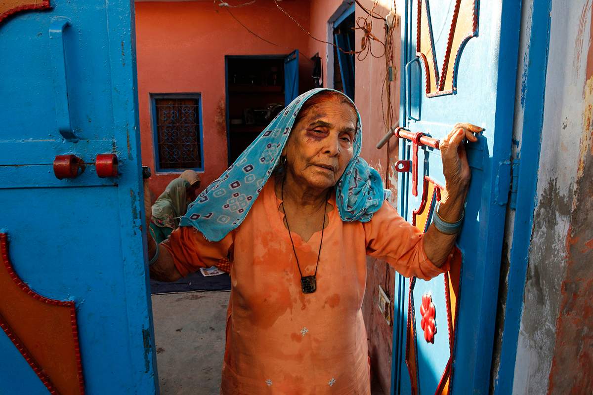 In this Sept. 30, 2015 file photo, a bruised Asgari Begum, mother of 52-year-old Muslim farmer Mohammad Akhlaq who was killed over rumors he slaughtered a cow, stands by the entrance of her home in Bisara, a village about 45 kilometers (25 miles) southeast of the Indian capital of New Delhi. 