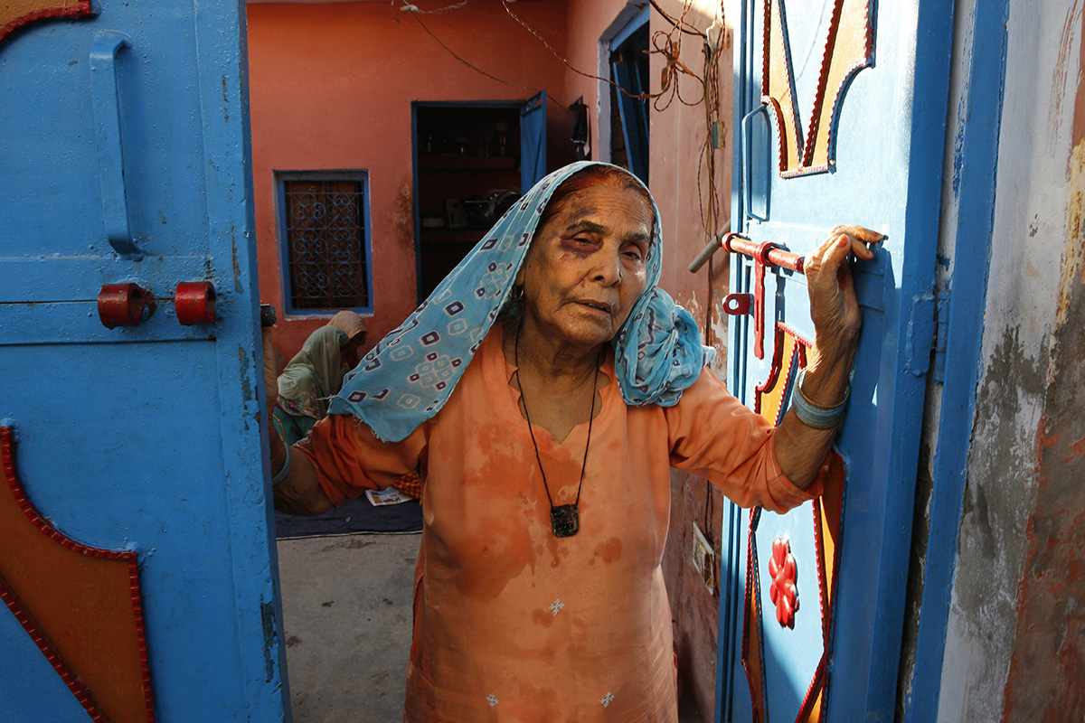 In this Sept. 30, 2015 file photo, a bruised Asgari Begum, mother of 52-year-old Muslim farmer Mohammad Akhlaq who was killed over rumors he slaughtered a cow, stands by the entrance of her home in Bisara, a village about 45 kilometers (25 miles) southeast of the Indian capital of New Delhi. 