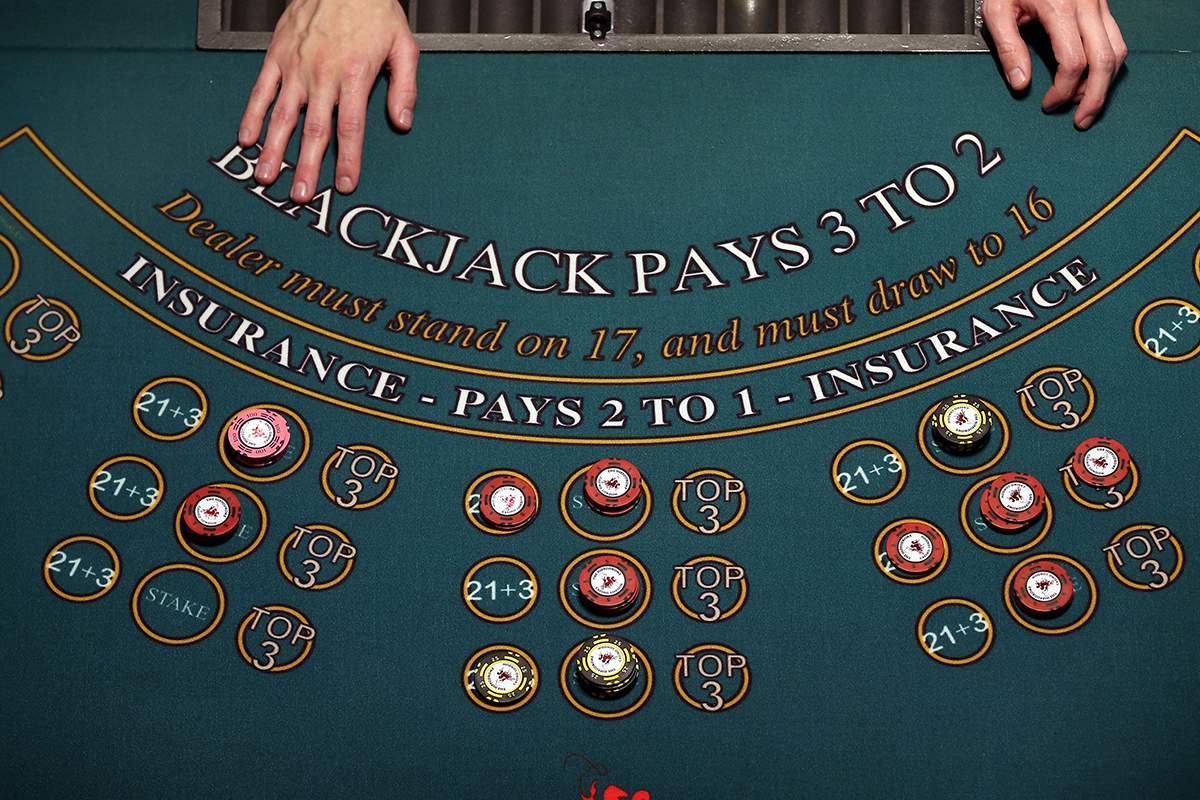  A croupier stands at a blackjack table. 